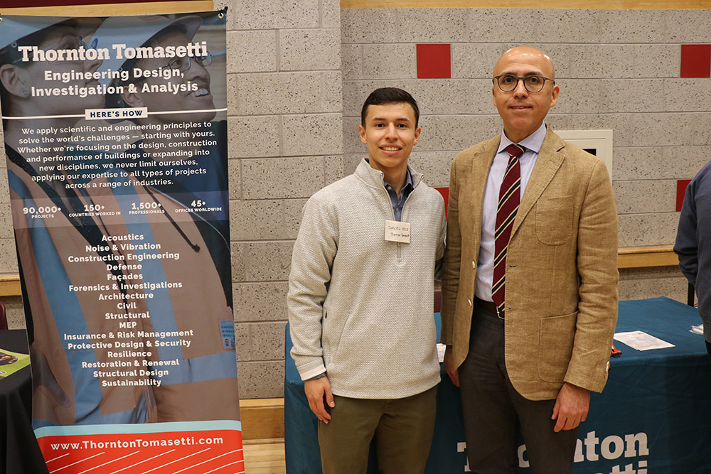 A professor and student in front of a table