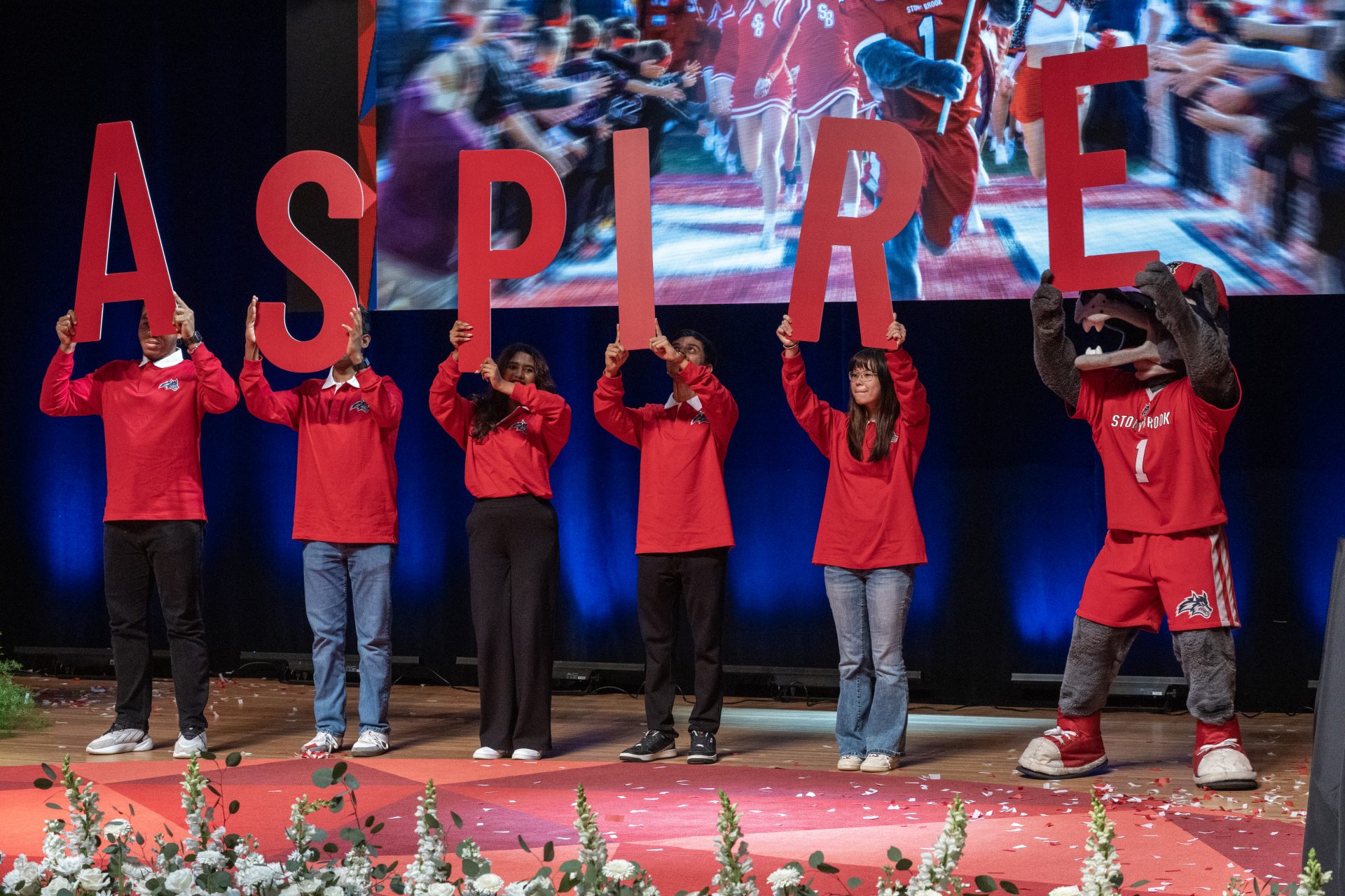 Students and Wolfie holding up letters to spell out ASPIRE
