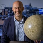 Timothy Glotch holding a globe