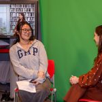 An alumni and student in front of a green screen for a workshop